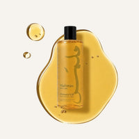 Malmas Sweet Almond & Honey Shower Oil bottle on a pool of the oil