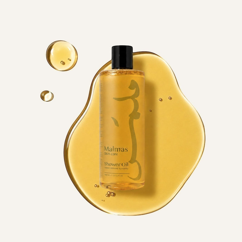 Malmas Sweet Almond & Honey Shower Oil bottle on a pool of the oil