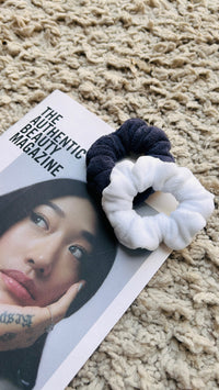 Two microfiber towel scrunchies resting on a magazine
