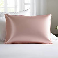 Esmé silk pillowcase in pink on a bed