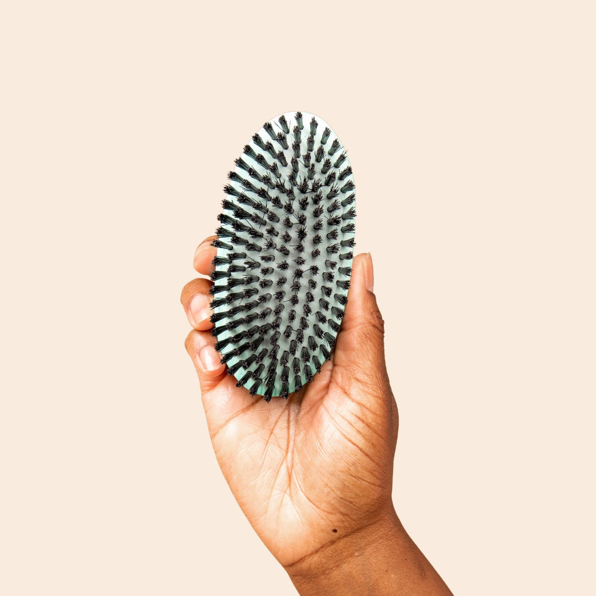 Bounce Curl Vegan Smoothing Brush held in a hand
